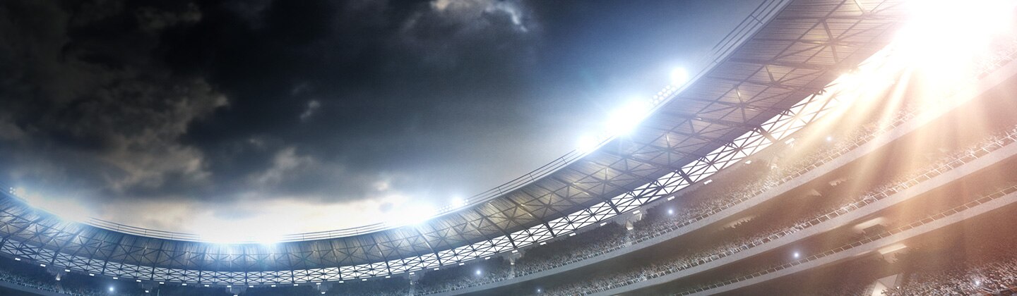 Samsung LEDs a full Olympic stadium shining brightly with its lights on the top on a cloudy night outside (key visual)